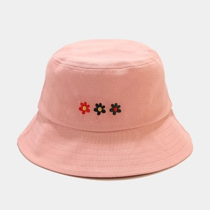 Close-up of pink bucket hat featuring delicate floral embroidery and cotton fabric texture