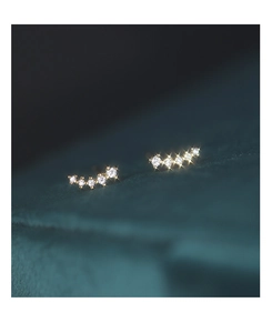 Macro shot of gold crescent moon earrings with gradient white cubic zirconia stones
