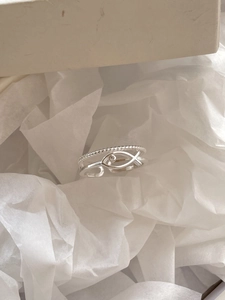 Macro shot of 925 sterling silver double-layered open ring with hollow fish and zircon