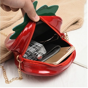 Red strawberry shaped patent leather crossbody bag showing internal capacity for daily items