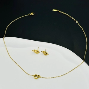 Detail of gold-plated stainless steel knot necklace and matching stud earrings set