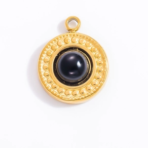 Detail of vintage 18k gold plated pendant with central black obsidian stone and bead border