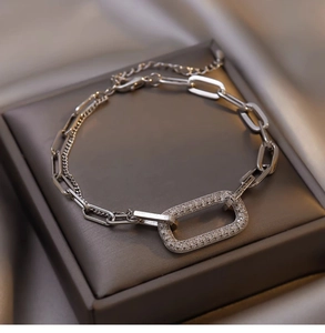Detailed close-up of zircon geometric chain bracelet with silver clasp on satin background