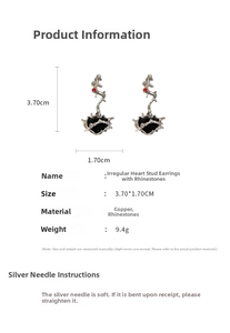 Detailed view of silver thorn texture earrings with black heart and red rhinestone accents