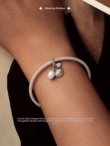 Détail du bracelet en argent S925 avec breloques perle, coquillage et cœur au poignet