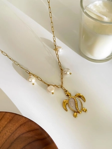 Detail of gold sea turtle pendant with freshwater pearls on a long link chain