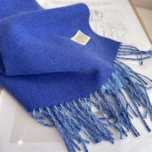 Detail of Klein blue cashmere-feel scarf showing soft knit texture and fringe design