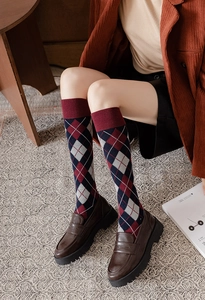Detailed close-up of retro argyle pattern knee-high socks with burgundy and navy diamonds