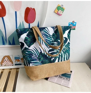 Detail of tropical leaf print canvas tote bag with rustic burlap handles and base