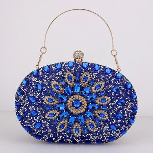 Detailed macro view of blue rhinestone evening bag with floral gemstone and gold handle