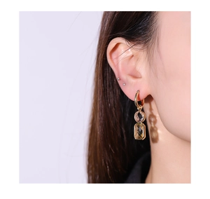 Macro detail of gold-plated hoop earrings with double-layered faceted champagne crystals
