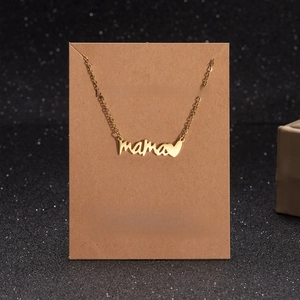 Macro shot of gold Mama heart pendant necklace on a brown Kraft gift wish card