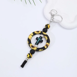 Detail of silicone sunflower ring keychain with black tassel and Jesus cross pendant