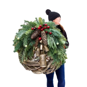 Large Christmas wreath with green pine needles, red berries, pine cones and vintage bells