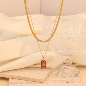 Detail of gold double-layer necklace with red enamel sun-eye and star-moon pendants