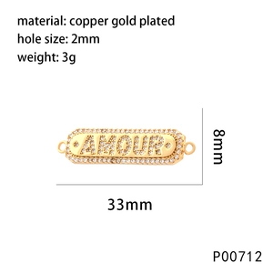 Macro view of gold plated copper connector charm with AMOUR text and zircon details