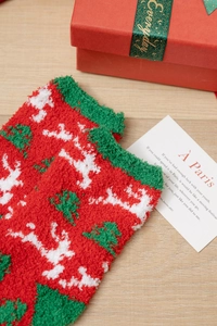 Detail von flauschigen Weihnachts-Korallenvlies-Socken mit Rentier- und Baummuster