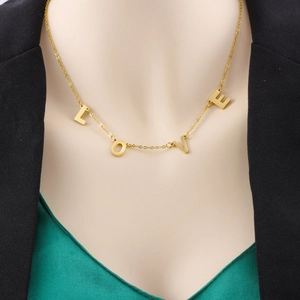 Elegante vergoldete Edelstahlkette mit LOVE Buchstaben-Anhängern, an Model gezeigt