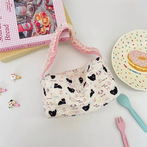 Close-up of quilted canvas bag with cartoon cat prints and pink lace-trimmed strap
