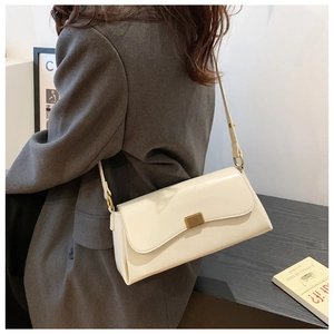 Weiße Leder-Achseltasche mit goldener Schnalle, getragen von einem Model im Studio