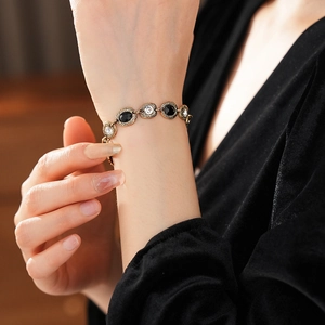 Gros plan d'un bracelet vintage avec pierres ovales noires et blanches sur le poignet