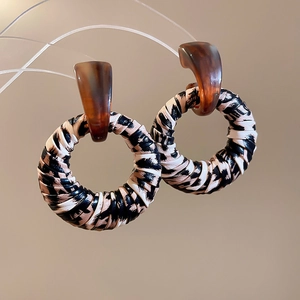 Detailed close-up of leopard print leather wrapped hoop earrings with resin hooks