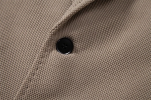 Détail macro du tricot gaufré kaki de qualité supérieure et du bouton noir chic