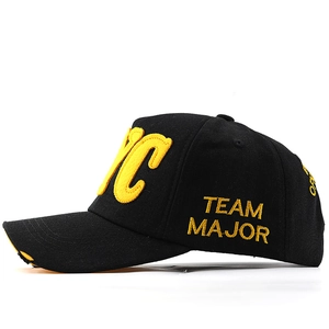Close-up of NYC yellow towel embroidery and distressed brim on black cotton baseball cap