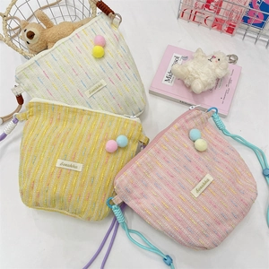Detailansicht bunter gestreifter Web-Handytaschen mit dekorativen Pompons und Kordel