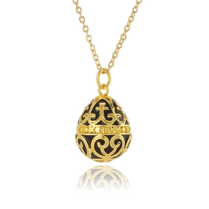 Detail of egg-shaped gold pendant with black enamel inlay and ornate cross patterns