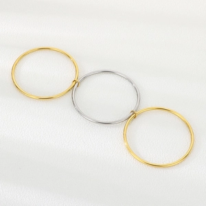 Macro detail of three interlocking 3mm stainless steel bangles in gold and silver finish