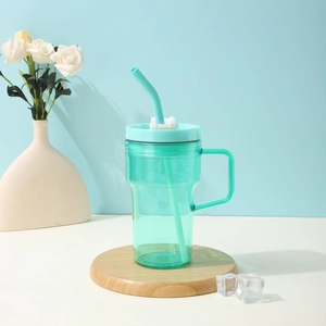 Green portable large capacity plastic straw cup with handle on a wooden base with ice