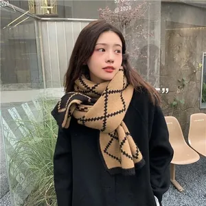 Detail of warm camel and black geometric diamond pattern knit scarf with lifestyle styling