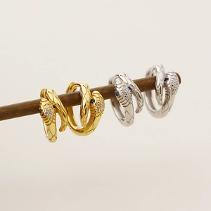 Detailed macro view of snake earrings with blue gemstone eyes and micro-inlaid zircon