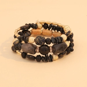 Detailed macro shot of bohemian multilayer beaded bracelet with black stones and gold beads