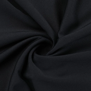 Macro d'un tissu en maille noire de haute qualité montrant la texture et le drapé doux