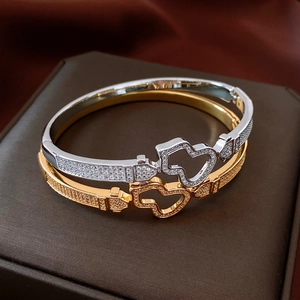 Macro detail of 18K gold and silver heart-shaped hollow buckles with inlaid rhinestones