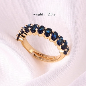 Adjustable gold plated copper ring featuring blue cubic zirconia stones, weight 2.8g