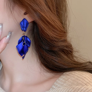Detail of blue petal drop earrings featuring matte layered tassels and gold links
