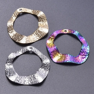 Detail of 18k gold plated hammered geometric charms in gold, silver and rainbow finish