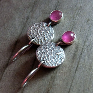 Vintage silver drop earrings with pink gemstones and hammered metal texture on wood