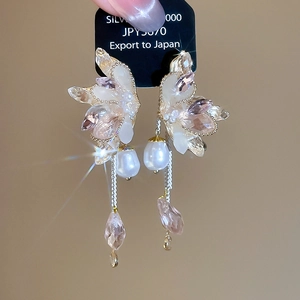 Detail of tassel earrings with crystal butterfly wings, pearls, and pink drop pendants