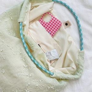 Detail view of floral embroidery canvas tote bag with woven handles and internal pocket