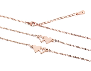 Macro shot of interlocking hearts on rose gold bracelet with 18KGP hallmark stamp