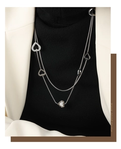 Double-layered silver necklace featuring hollow heart charms and a sparkling pave heart pendant