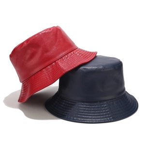 Detail of red and navy PU leather bucket hats showing high-quality texture and stitching