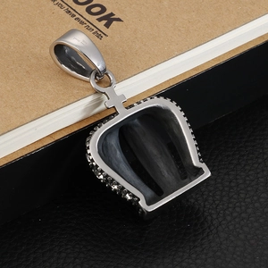 Macro detail of silver crown pendant showing 316L stainless steel hallmark and crystals