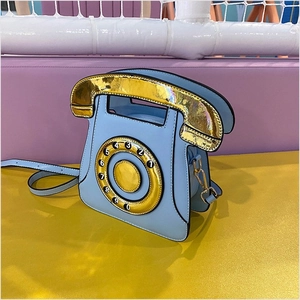 Detailed view of creative light blue retro telephone crossbody bag with gold dial