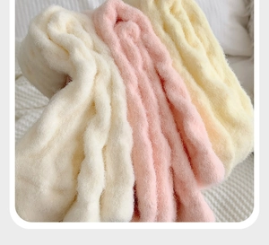 Macro shot of soft thick plush coral fleece socks in pastel cream pink and yellow colors