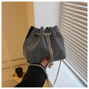 Detail of a sparkling black rhinestone bucket bag with chain strap and pearl accents
